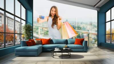 Portrait beautiful young asian woman happy and smile with credit card for shopping bag from department store Wall mural