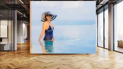 Portrait beautiful young asian woman relax around swimming pool in hotel resort Wall mural