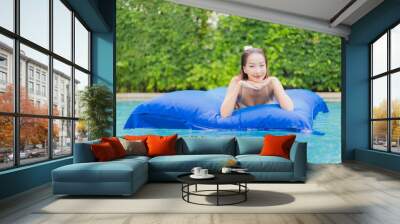 Portrait beautiful young asian woman relax smile around outdoor swimming pool in hotel resort Wall mural