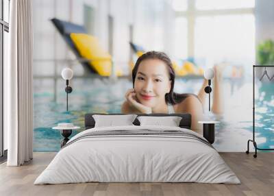 Portrait beautiful young asian woman relax smile around swimming pool in hotel resort Wall mural