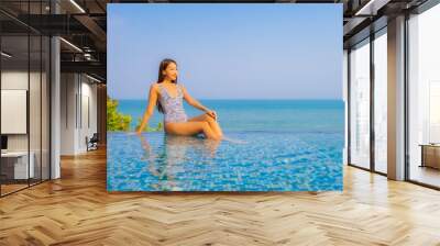 Portrait beautiful young asian woman relax smile enjoy leisure around swimming pool Wall mural