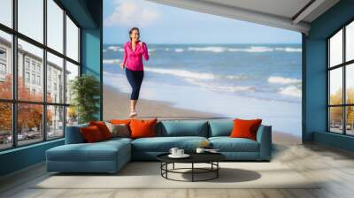 Portrait beautiful young asian woman running or exercise on the tropica nature landscape of beach Wall mural