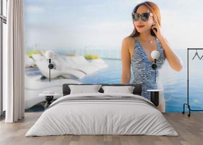 Portrait beautiful young asian woman smile happy relax around swimming pool in hotel resort for leisure Wall mural