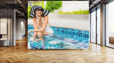 Portrait beautiful young asian woman smile happy relax around swimming pool in hotel resort Wall mural