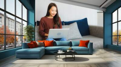 Portrait beautiful young asian woman use computer laptop on sofa Wall mural