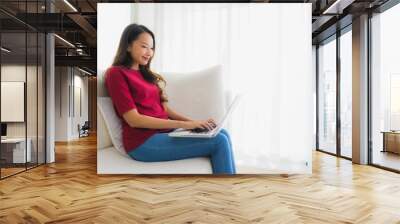 Portrait beautiful young asian women using computer laptop on sofa chair Wall mural