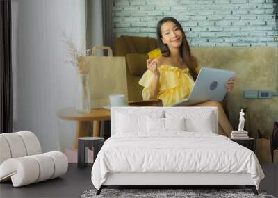 Portrait young asian woman using laptop for shopping online with coffee cup and book Wall mural