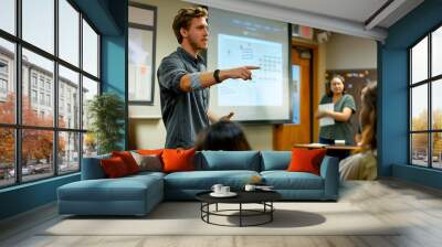 A university student giving a presentation in a seminar room, pointing to a slide on the projector screen while classmates listen  Wall mural