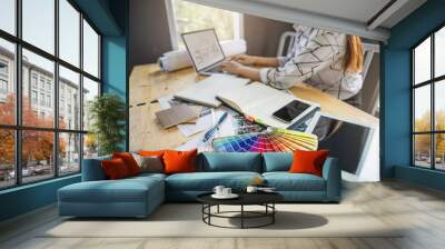 Architect designer Interior creative working hand drawing sketch plan and selection material color.  Young designers are using a laptop, discussing ideas and smiling while working in office. Wall mural