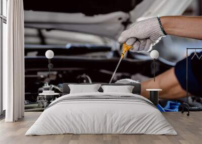 Close up of Automotive mechanic repairman pulling dipstick to checking engine oil level engine in the engine room, check the mileage of the car, oil change, auto maintenance service concept. Wall mural