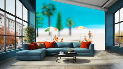 Miniature people wearing swimsuit relaxing on the beach Wall mural