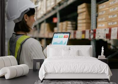 Warehouse Supervisor in safety suite using digital tablets to check the stock inventory on shelves in large warehouses, a Smart warehouse management system, logistic network technology concept. Wall mural