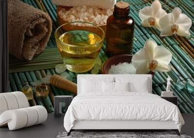 Photo of a spa sitting with orchids and salt, oil in a glass, soap, palm, on a mat. Wall mural