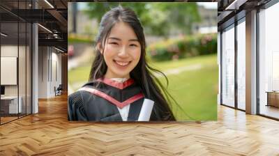 Photo of successful university graduation Smiling beautiful Asian girl university or school graduate standing with diploma over university background Wall mural