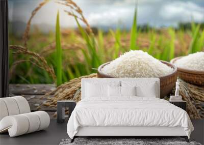 Photo of white rice and paddy rice on a wooden table with rice plants background Wall mural