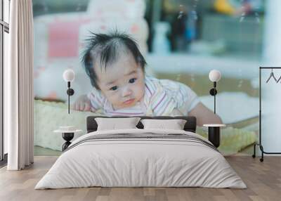 Baby Tummy Time on Soft Cushion with Curious Expression Wall mural