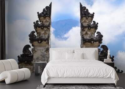 Young women watching view of the Agung volcano near sculpture gate in Pura Penataran Agung Lempuyang in Bali, Indonesia Wall mural