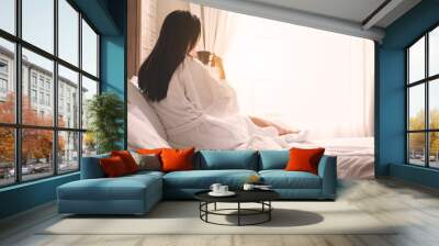 asian woman relaxing in the hotel room, drinking morning coffee, copy space Wall mural