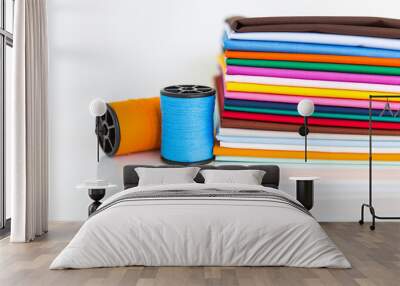 Colorful stack of fabric and blue and orange thread on white background, sewing thread and cotton cloth, textile or tailor industry Wall mural