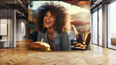 A happy woman eating a burger in an outdoor restaurant as a Breakfast meal craving deal. Wall mural