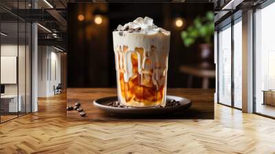 Iced latte with milk poured into the cold cup on wooden background Wall mural