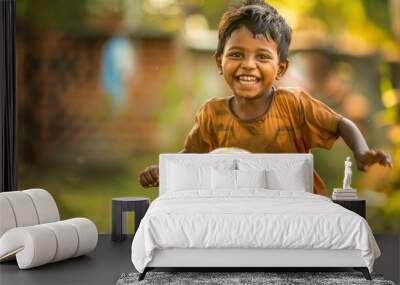 Indian happy kid playing soccer or holding football outdoors Wall mural