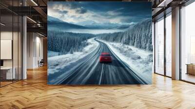 Red car driving on winding road through snowy forest, toning blue. Wall mural