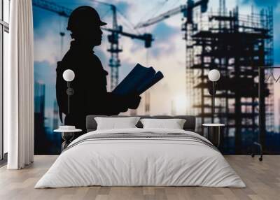 A lone silhouette of an engineer examining blueprints with a backdrop of cranes and scaffolding in the distance , abstract  , background Wall mural