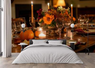 A table with a pumpkin, candles, and flowers on it. The table is set for a Thanksgiving dinner Wall mural