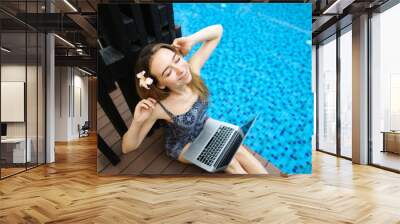 Sunny portrait of female stretches hands And laptop keyboard aft Wall mural