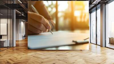 Businessman s hand signing a critical contract, sunlight illuminating the desk, blurred office walls Wall mural