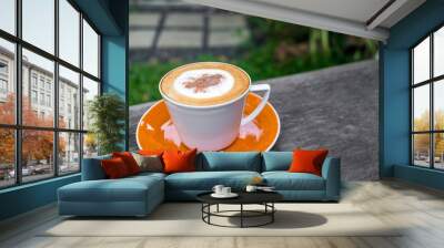 Cappuccino coffee in white cup on wooden table in garden Wall mural