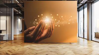 Hand praying with magic light that flows through on orange bokeh background. Wall mural