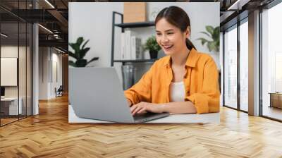 Happy female students using social media on internet with laptop at home. Wall mural