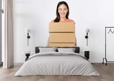 Smiling beautiful Asian woman holding cardboard boxes on white background. Concept delivery online. Wall mural