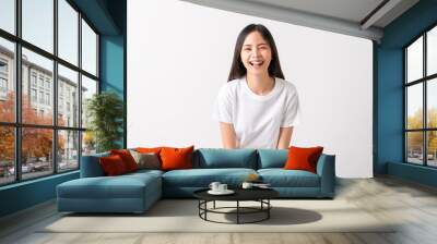 Studio shot of cheerful beautiful Asian woman in white t-shirt and stand on white background. Wall mural