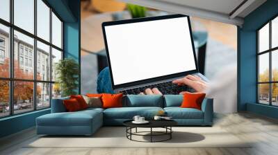 Woman hand type on the keyboard on laptop with mockup of blank screen for the application. Wall mural