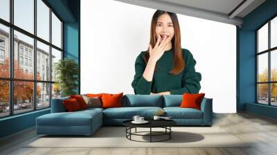 Young Asian woman exudes happiness, displaying a joyful expression as she stands against a white background. Wall mural