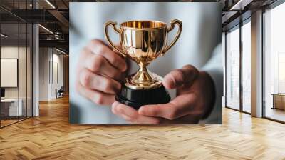 A businessman holding a trophy with pride during a corporate award ceremony Wall mural