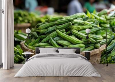 A close-up of fresh okra (Abelmoschus esculentus) in a market basket, ready for sale Wall mural