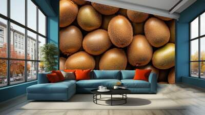 A close-up of market-ready kiwifruits (Actinidia deliciosa), with their fuzzy brown skins and green interiors Wall mural