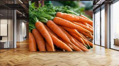 A display of fresh carrots (Daucus carota) with vibrant orange roots, ready for sale at the market Wall mural