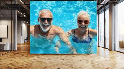 A smiling two man and woman splash happily in a blue pool on a summer day seniors doing water exercises, Group of elder women at aqua gym session, joyful group  Wall mural