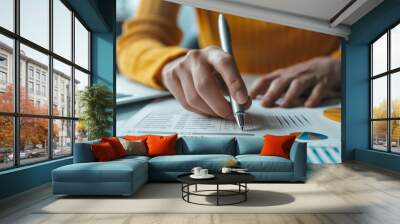 Businesswoman analyzing financial report with laptop computer on desk. Wall mural