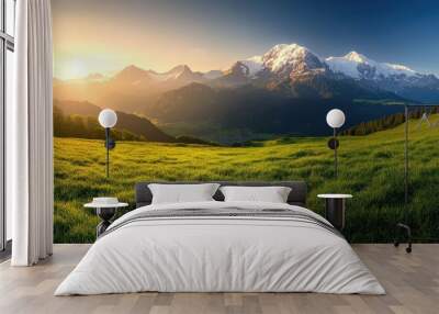 The breathtaking views of the Swiss Alps, with snow-capped peaks and rolling green meadows under a clear sky at sunrise Wall mural