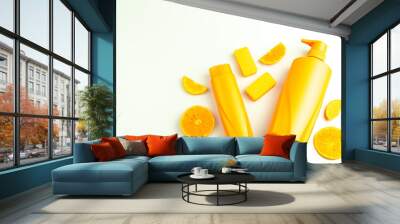 Orange shampoo bottles and pieces of orange on white background Wall mural