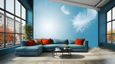 Lightly Soft of fluffy a white feather floating in the sky. Feather abstract freedom flying in heaven concept. Wall mural