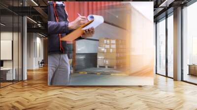 Warehouse worker holding clipboard his control loading package boxes goods into cargo container truck. supply chain shipment. cargo truck freight. shipping warehouse logistics and transportation. Wall mural