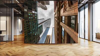 Wide-angle view looking up through tall buildings and skyscrapers in downtown Chicago Illinois Wall mural