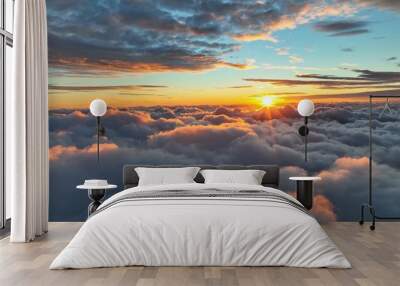 Sun goes into the clouds. Epic sunset in the sky, aerial shot. Flying above the clouds illuminated by the evening sun Wall mural